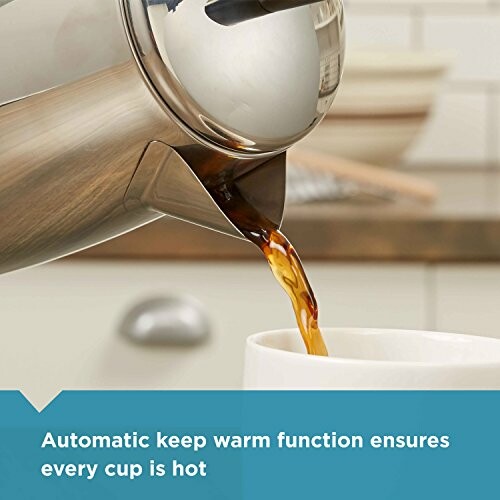 Close-up of coffee being poured into a cup with text about automatic keep warm function.