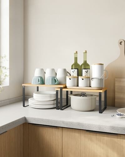 Kitchen counter with mugs, plates, bottles, and a pot organized on a shelf.