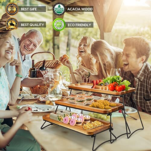 Group enjoying outdoor picnic with tiered wooden food display.