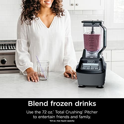 Woman using Ninja blender to make frozen drinks in kitchen.